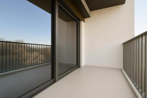 ドバイにあるSleek New Studio in Meydan, Fully Equipped and Spaciousの眺めの良いガラスのドアが付いた空のバルコニー +3枚の写真