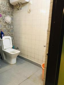 デヘラードゥーンにあるWhispering Pines Studiosのトイレとタイル張りの壁があるバスルーム