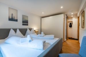 two beds in a room with two blue chairs at Schneehaus Chalet in Ehrwald