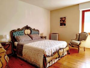 sypialnia z dużym łóżkiem i krzesłem w obiekcie Maison Seguret, respiro montagna w mieście Oulx