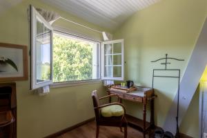 una piccola stanza con una scrivania e una finestra di Maison d'hôtes, Calme et Piscine a Habas