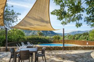 a patio with a table and chairs and a pool at Can Miquel pollensa in Pollença