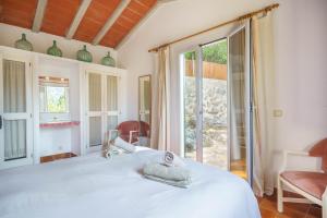 a bedroom with a white bed and a large window at Can Miquel pollensa in Pollença