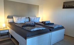 a large bed with two pillows on top of it at Moderne Ferienwohnungen am Kurpark - zentral, ruhig & nah am Edersee in Bad Wildungen