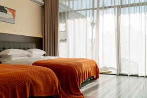 a bedroom with two beds and a large window at Wuyi Whispering Maple in Dali