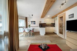 ラ・ヴィッラにあるCiasa Irene Dreizimmerwohnungのキッチン、リビングルーム(赤い敷物付)