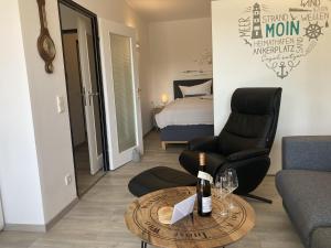 a living room with a chair and a table with wine glasses at Berolina 125 - Sonnenseite in Dahme +39 photos