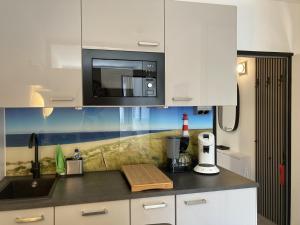 a kitchen with a counter top with a microwave at Berolina 125 - Sonnenseite in Dahme