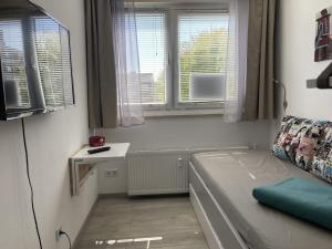 a small room with a bed and two windows at Berolina 125 - Sonnenseite in Dahme