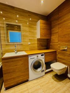 a bathroom with a washing machine and a sink at Shiraz Park Pogórze in Pogórze