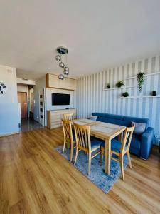 a living room with a table and a blue couch at Shiraz Park Pogórze in Pogórze