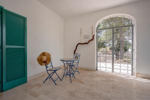 ein Raum mit zwei Stühlen und einem Tisch und einer Tür in der Unterkunft GuestHost - Borgo Lucia Villa Magnolia in Selva di Fasano