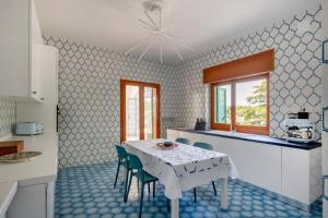 eine Küche mit einem Tisch und Stühlen in einer Küche in der Unterkunft GuestHost - Borgo Lucia Villa Magnolia in Selva di Fasano