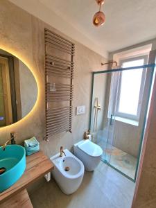 a bathroom with a sink and a toilet and a mirror at Lecco Antico Pozzo - Modern Suite in Lecco
