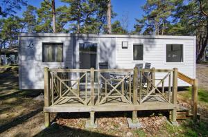 a tiny house with a porch and a deck at Tiny Homes Nr 822 in Göhren