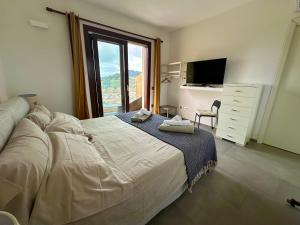 una camera da letto con un letto grande e una finestra di Studios con vista a Villasimius