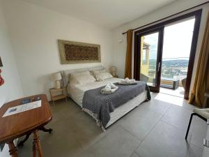 una camera da letto con un letto e una grande finestra di Studios con vista a Villasimius