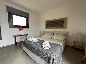una camera da letto con un letto con due asciugamani sopra di Studios con vista a Villasimius