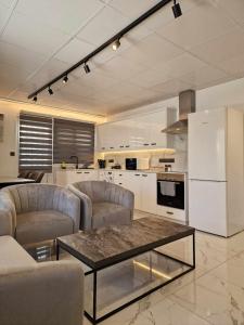 a living room with couches and a table in a kitchen at Modern House in Touristic Pyla - Oroklini! in Larnaka