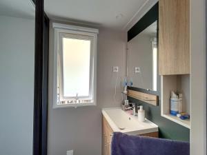 a bathroom with a sink and a window at Mobilhome Le Nid Douillet in Mimizan-Plage