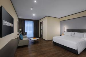 ナゴヤにあるHarper Premier Nagoya Batamのベッドとテレビがあるホテルの部屋