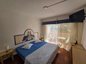a bedroom with a blue bed and a balcony at Monte Treasure - Beach, Wifi, Pool, Parking in Monte Gordo +57 photos