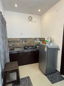 a kitchen with a stainless steel refrigerator and a sink at The Sea Shelter Garden Villa in Mahabalipuram