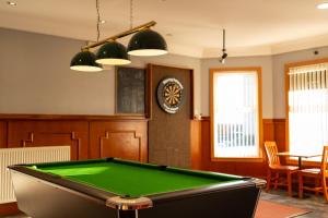 a room with a pool table and a clock at Station Hotel in Ellon