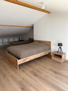 a bedroom with a bed and a wooden floor at Appartements neufs avec garages dans maison de village in Andance