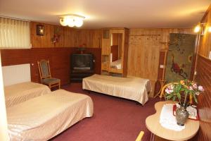 a hotel room with two beds and a television at Guest House Linas in Alytus