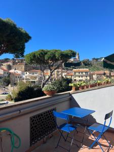 a blue table and chairs on a balcony with a view at Cav Casa Brunella in Castiglione della Pescaia