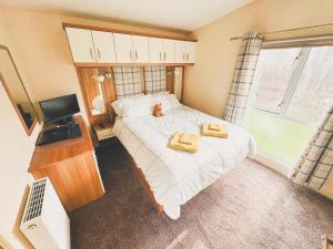 a bedroom with a bed with two towels on it at Seaside Escapes With Laura in Port Seton +32 photos