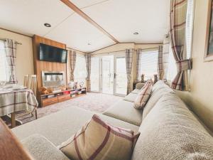 a living room with a couch and a tv at Seaside Escapes With Laura in Port Seton