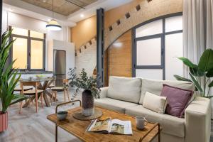 ein Wohnzimmer mit einer Couch und einem Tisch in der Unterkunft Suites Maestranza - Herrería by Magno Apartments in Sevilla
