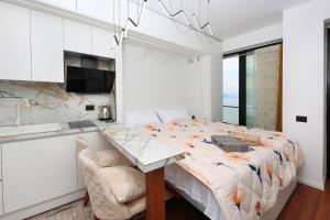 a bedroom with a large bed and a table at Joelisrentapartments monolocale e bilocale in Vlorë