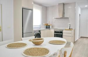 a kitchen with a white table and chairs and a refrigerator at Chalet Ruperto III in Conil de la Frontera +22 photos