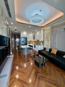 a living room with a black couch and a kitchen at Cozy Homestay Diamond Crown Hải Phòng in Ðông Khê