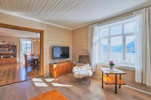 a living room with a television and a table at Solheim Gard in Stryn