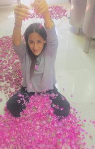 a girl is sitting on a pile of pink flowers at Kasbah Alami in Kalaat MGouna