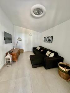 a living room with a black couch and a table at VILLA MAR in Cala'n Bosch