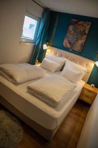 a bedroom with a large bed with white sheets and pillows at Penthouse, Sonnenbalkon, Netflix in Saarbrücken