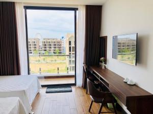 a hotel room with a bed and a large window at Melanta Hotel - FLC Sầm Sơn in Sầm Sơn