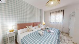 a bedroom with a bed with two stuffed animals on it at Apartamentos Consuegra frente a los molinos in Consuegra