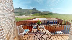 a balcony with a table and a view of a hill at Apartamentos Consuegra frente a los molinos in Consuegra