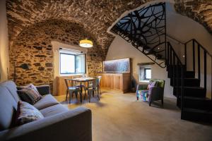 a living room with a staircase and a table and chairs at Torre di Baratti Bio Resort in Populonia