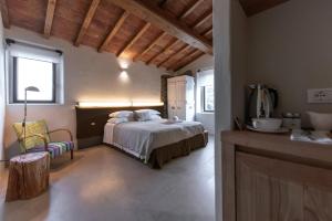 a bedroom with a bed and a chair in a room at Torre di Baratti Bio Resort in Populonia