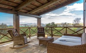 a patio with a bed and chairs and a table at Torre di Baratti Bio Resort in Populonia