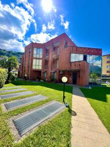 a brick building with solar panels in front of it at house prua a step from the lake in Bellano
