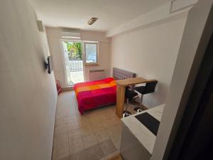 ein Schlafzimmer mit einem Bett, einem Schreibtisch und einem Fenster in der Unterkunft Apartments Knežević in Jadranovo