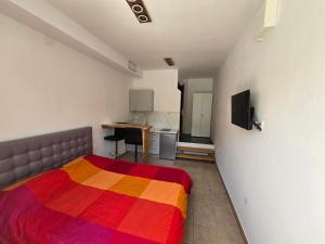 Zimmer mit einem Bett mit einer bunten Decke in der Unterkunft Apartments Knežević in Jadranovo